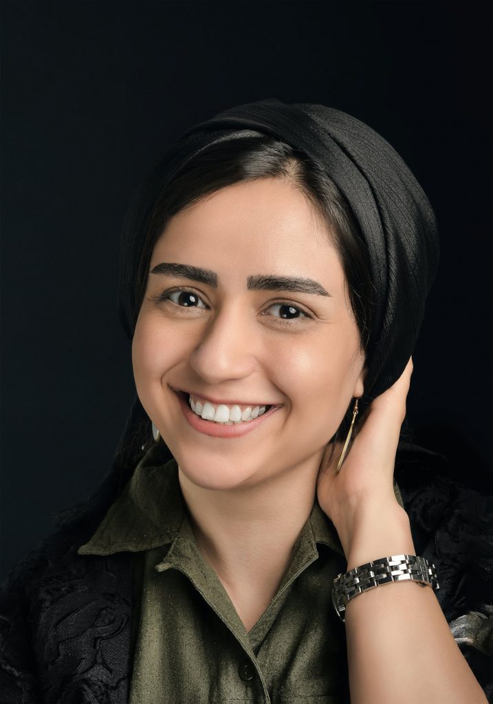 Woman in black headscarf, serious expression